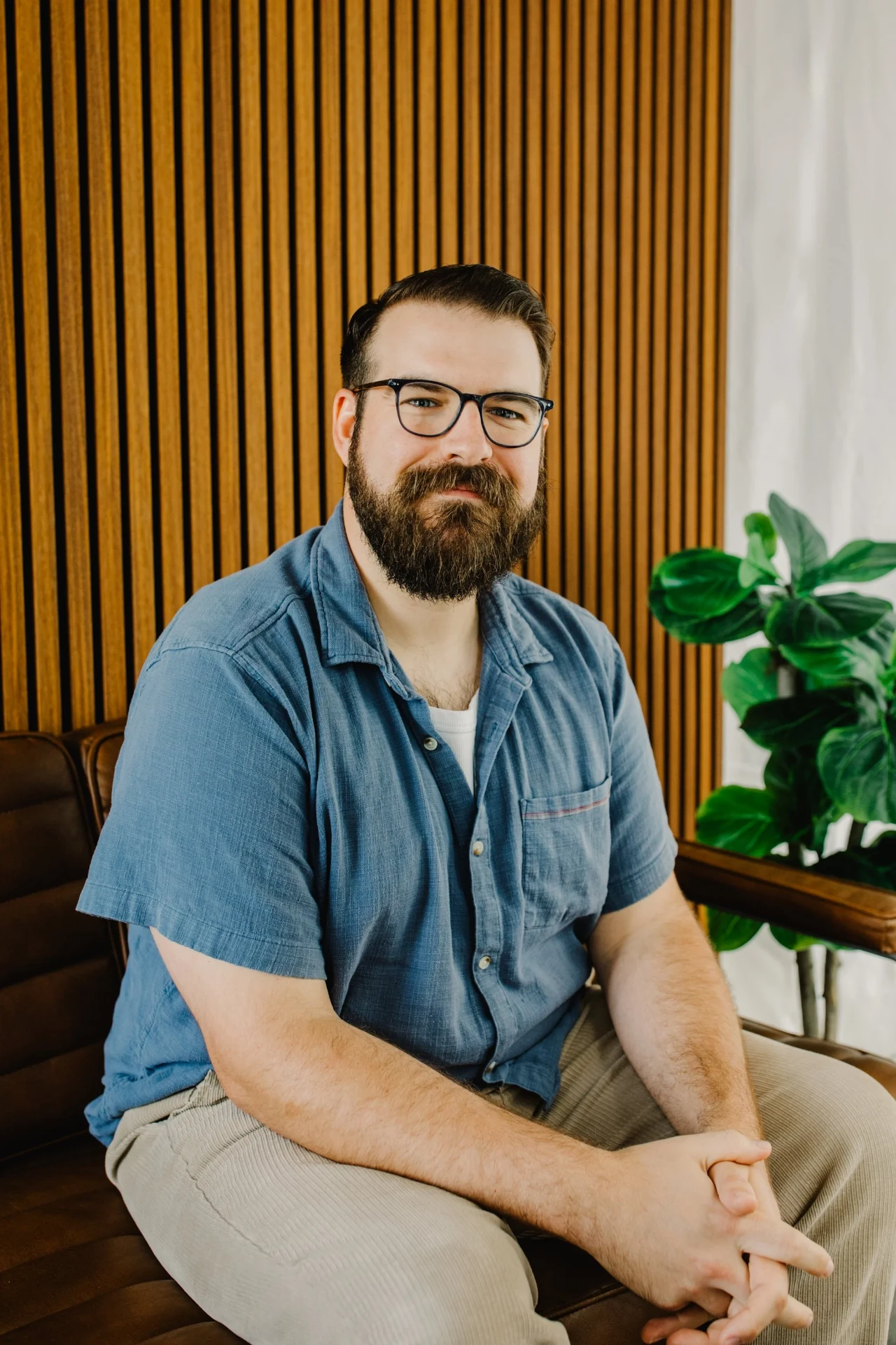 Sheldon Clark seated in his counseling office beside a houseplant